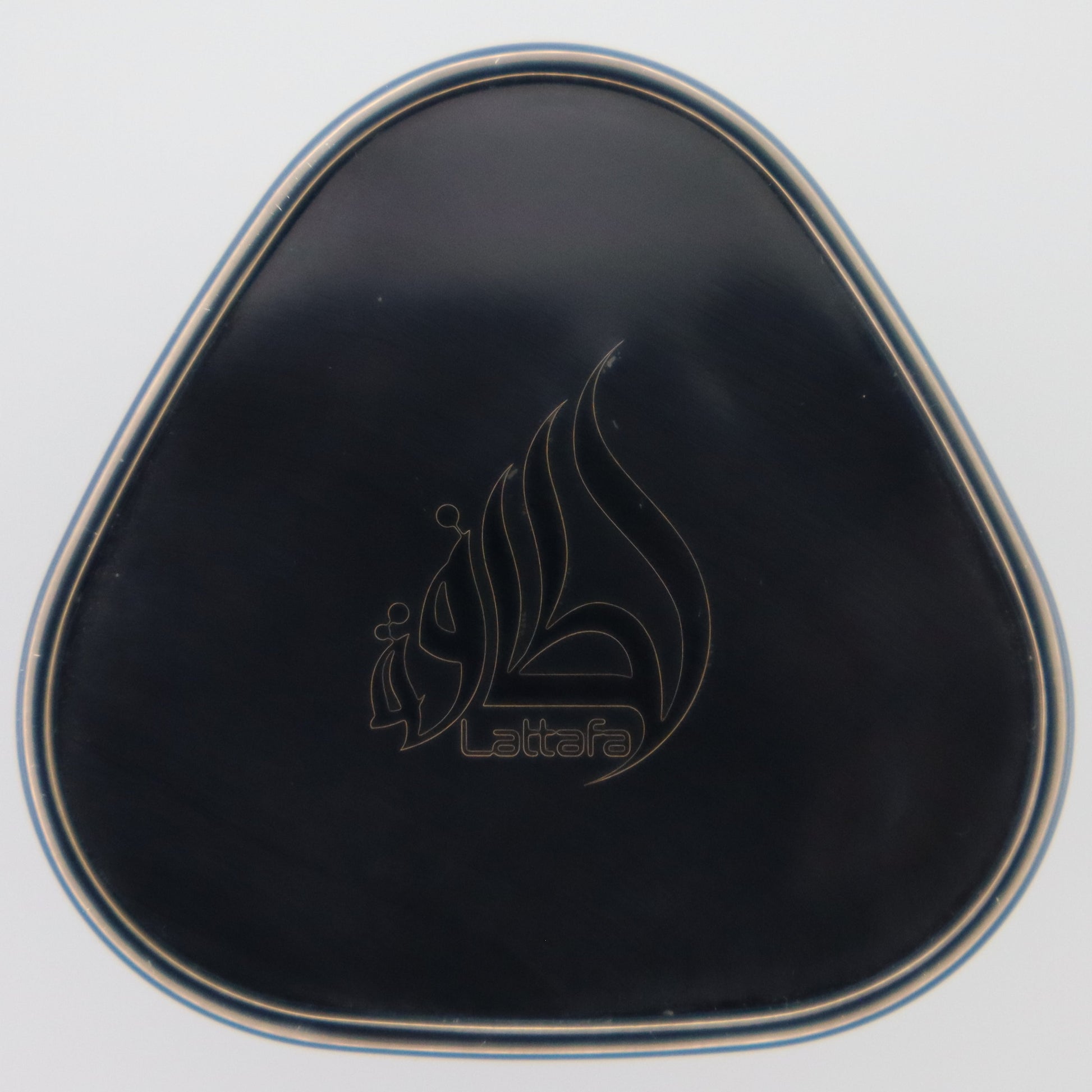 A black triangular compact perfume cap with a silver metallic border and an engraved Lattafa logo in the center, set against a plain white background.