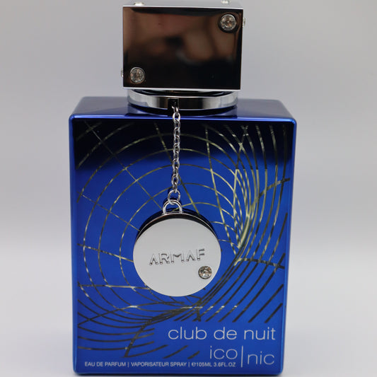 Blue perfume bottle with a circular tag bearing the embossed brand name 'ARMAF'. The bottle has details including 'club de nuit' and 'ico|nic'.