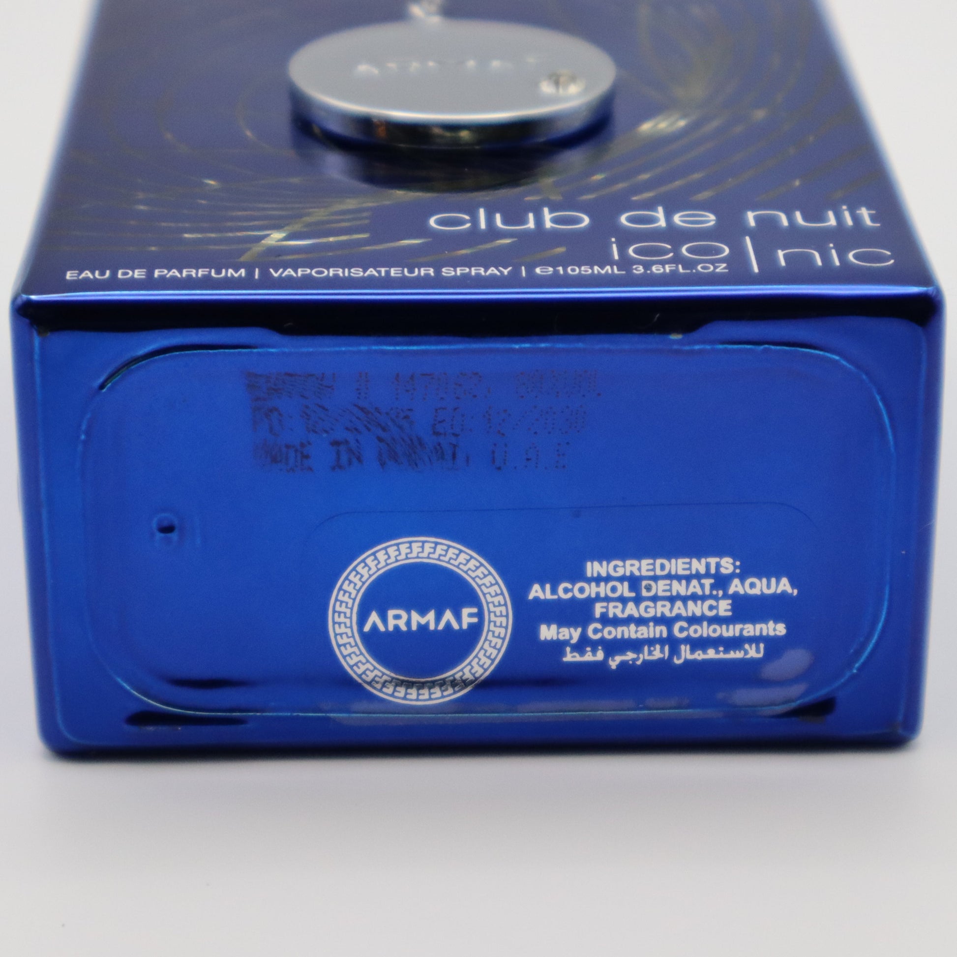 A close-up shot of the blue perfume bottle for ARMAF Club de Nuit Iconic EDP, showing the bottom with product details and an ARMAF logo.